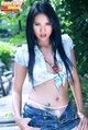Nancy ho standing with hands on hips long hair wearing blue knotted shirt and denim shorts