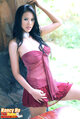 Nancy ho leaning against wall wearing crimson dress long hair over her shoulders