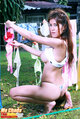 Squatting at washing line hanging up bra looking over her shoulder long hair
