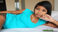 Lying on bed wearing green top in leopard print shorts