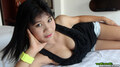 Lying on bed wearing black top showing cleavage